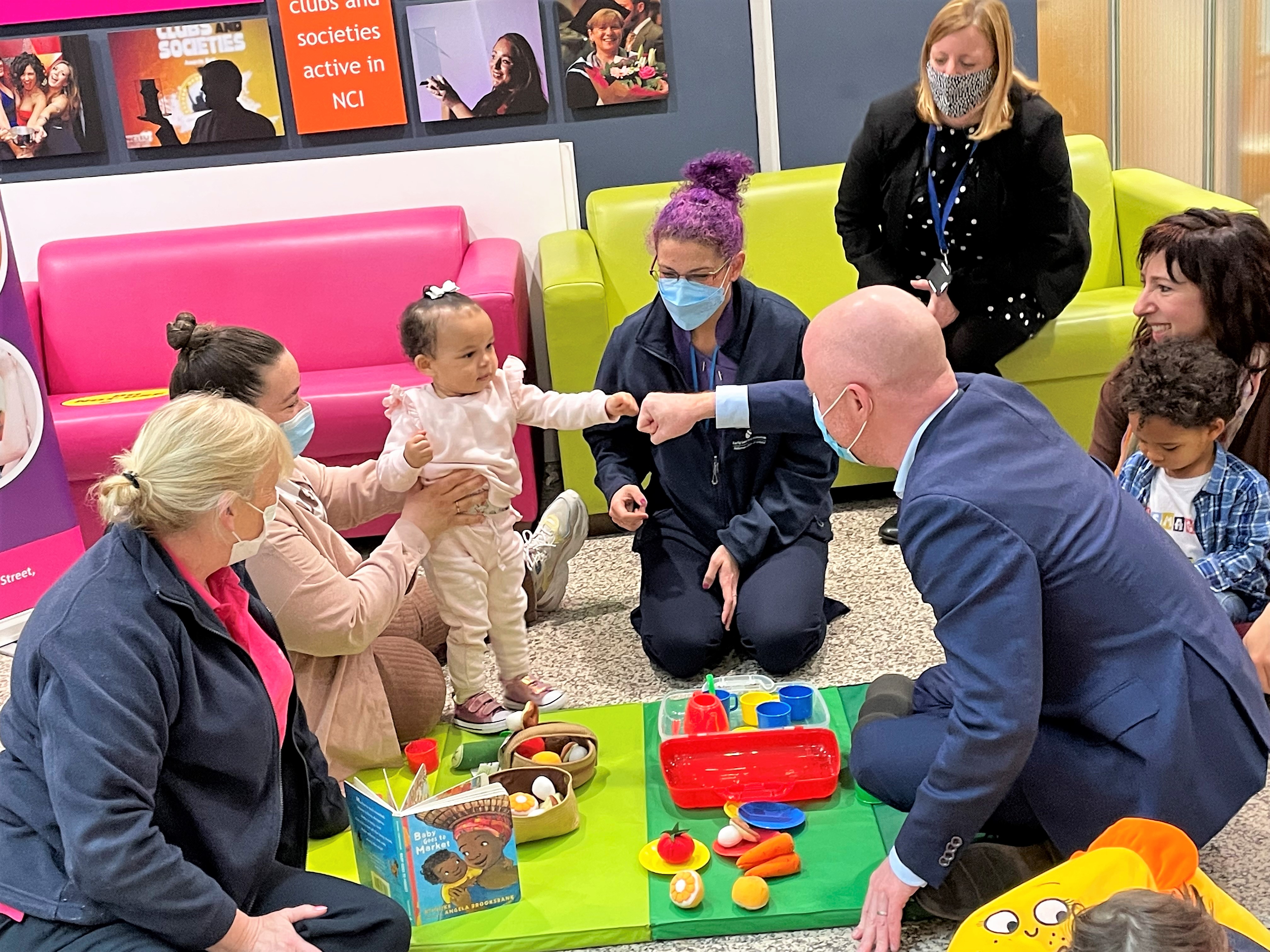 Minister for Health Stephen Donnelly with NEIC families - 17-month old Luna Rose fist bumps the minister.