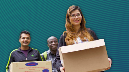 NCI student holding a cardboard box full of belongings