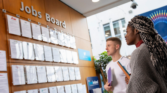 NCI students reading the jobs board notices on campus