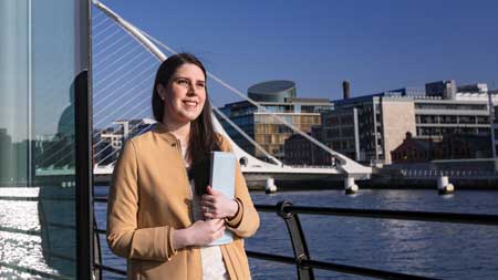 Student standing beside River Liffey in Dublin