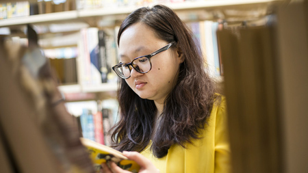 Student reading a book in NCI library