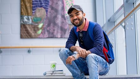 NCI Student sitting on steps on campus