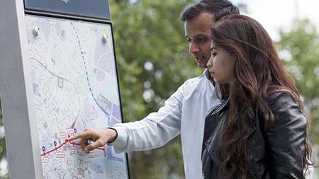 Two people pointing at a map 