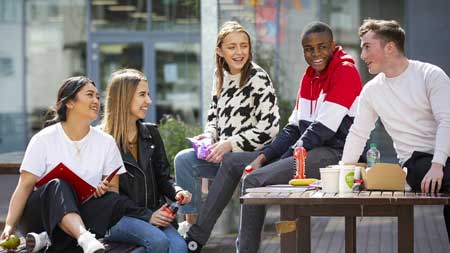 NCI undergraduate students sitting in courtyard