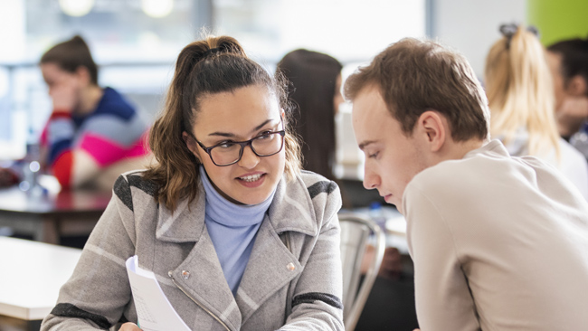 NCI student showing another student a document