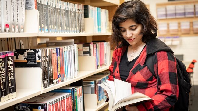 NCI student reading a book in NCI library