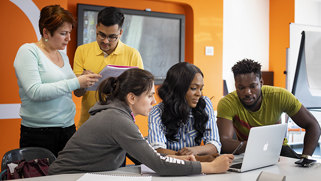 Group of NCI students working on a laptop