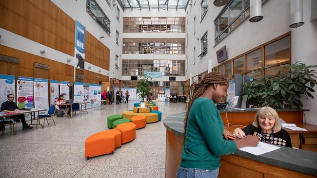 Student signing a form at main reception in NCI