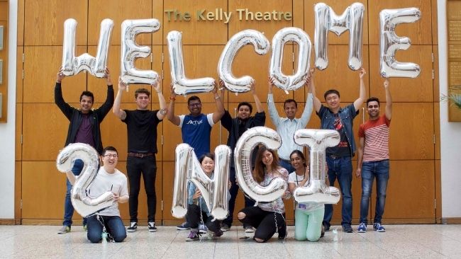 NCI students holding balloons that spell out "Welcome to NCI"