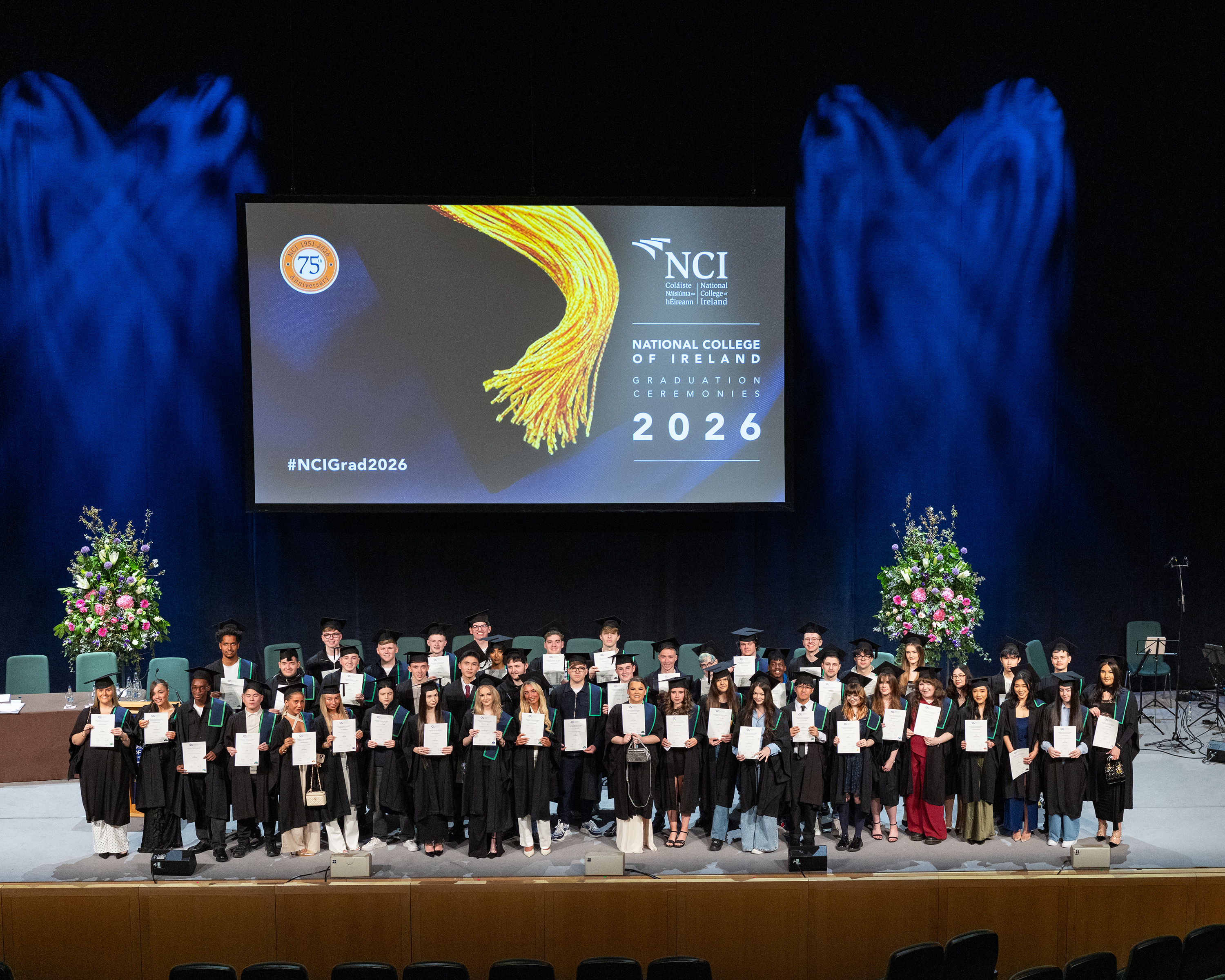 A group of students on stage at a graduating ceremony