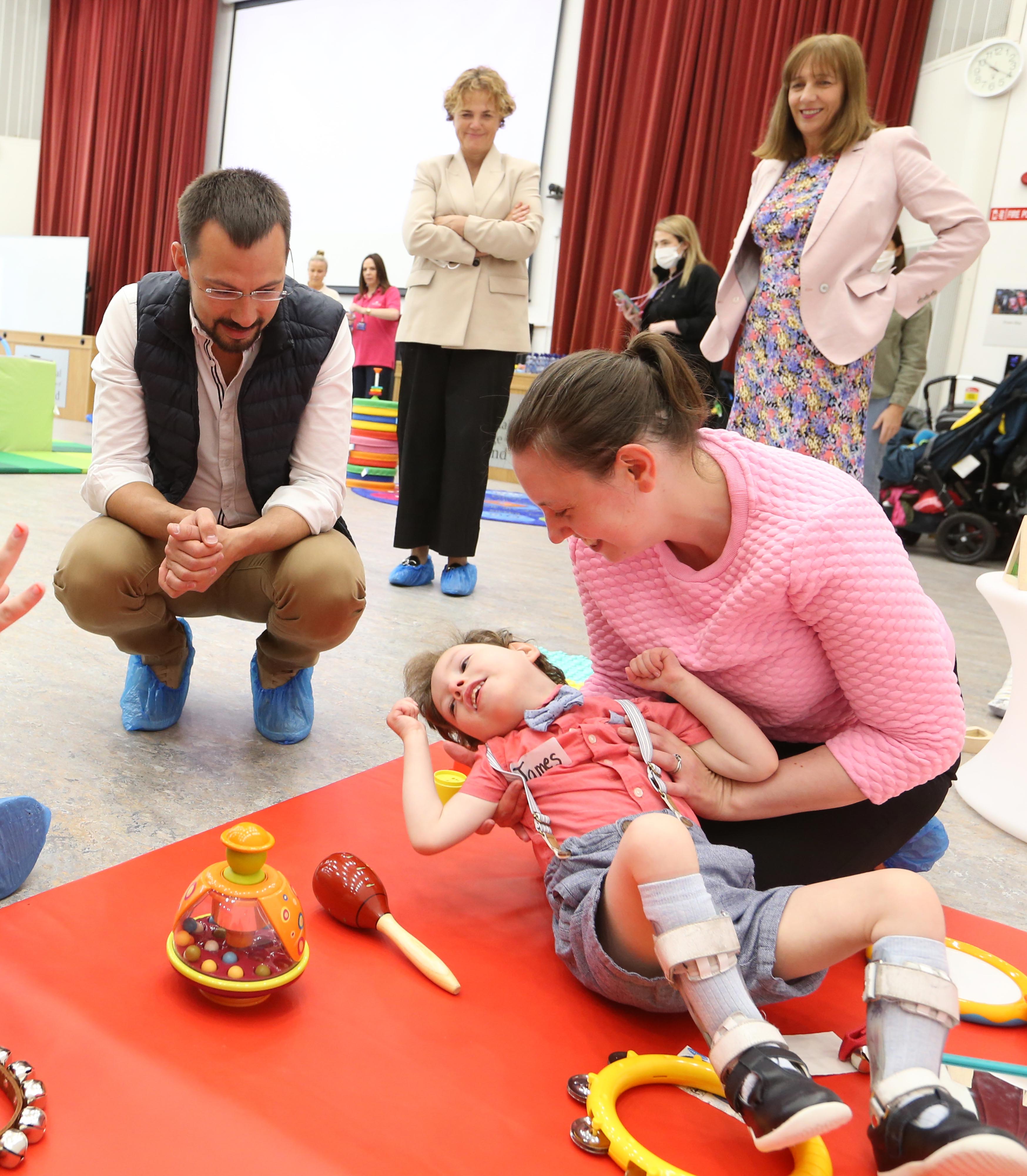 Vlad Yatsenko, co-founder of Revolut, talks to Louise Corrigan and her son James Garraghan at a Parenting 365 toddler play group delivered by the Early Learning Initiative at NCI, In the background, CEO of Community Foundation Ireland, Denise Charlton, and President of NCI, Gina Quin