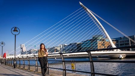 Student walking beside the Samuel Beckett Bridge in Dublin Docklands